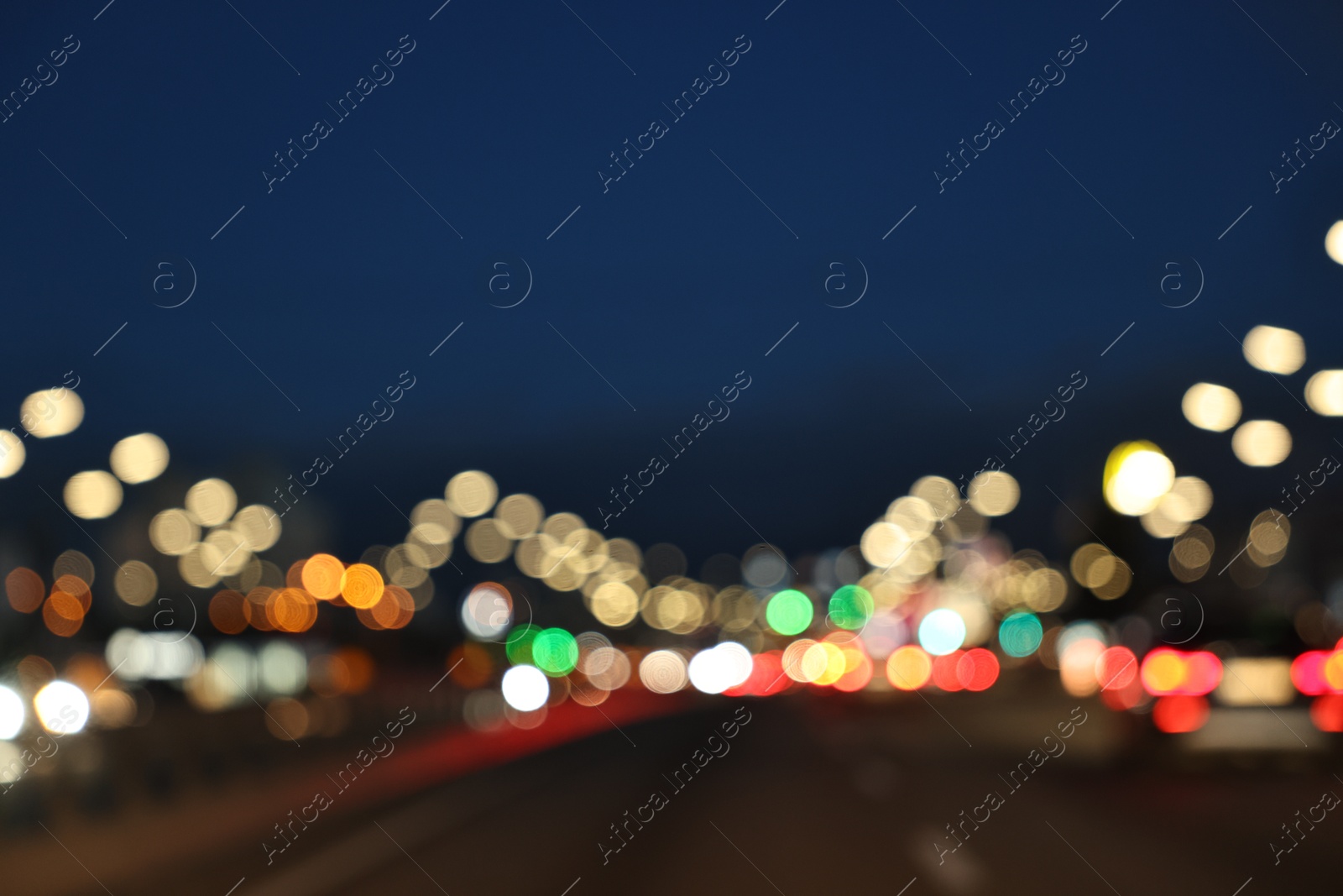 Photo of Blurred view of cityscape with road traffic and street lights in evening