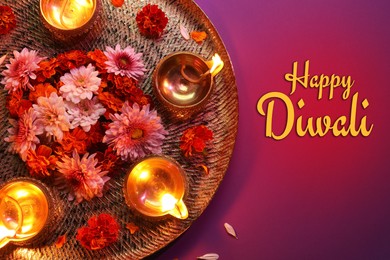 Image of Happy Diwali greeting card, Hindu festival of lights. Diya lamps and beautiful flowers on purple background, top view