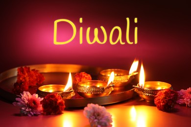 Image of Happy Diwali greeting card, Hindu festival of lights. Diya lamps and beautiful flowers on color background