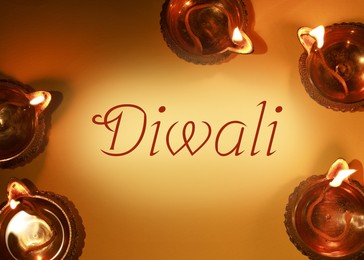 Image of Happy Diwali greeting card, Hindu festival of lights. Diya lamps on orange background, flat lay