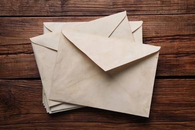 Old letter envelopes on wooden table, top view