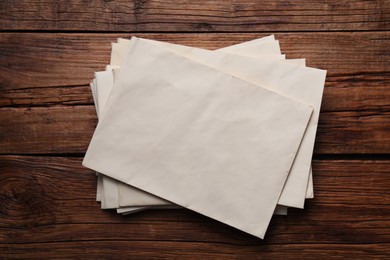 Old letter envelopes on wooden table, top view