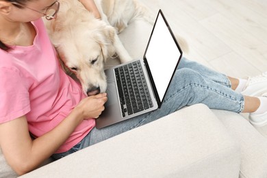 Photo of Online pet shop. Woman with laptop making order for cute Golden Retriever dog at home, closeup