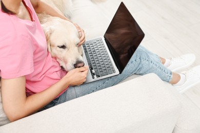 Photo of Online pet shop. Woman with laptop making order for cute Golden Retriever dog at home, closeup