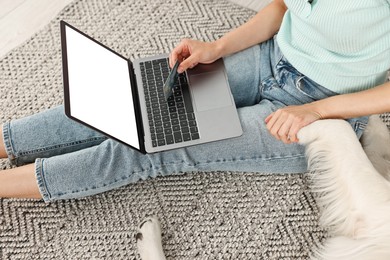 Photo of Online pet shop. Woman with laptop, credit card and cute Golden Retriever dog making order at home, closeup