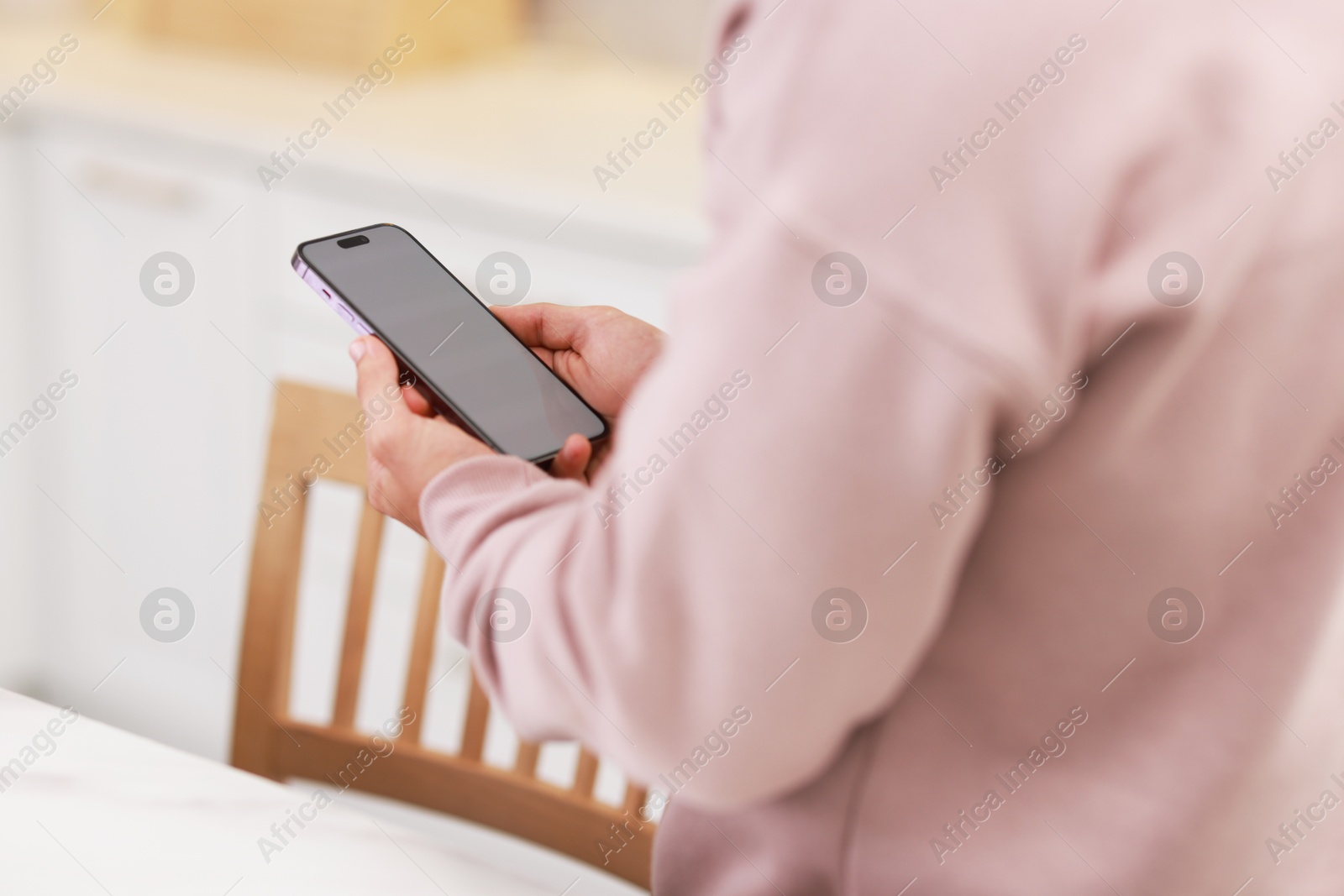 Photo of Man using modern smartphone indoors, closeup view