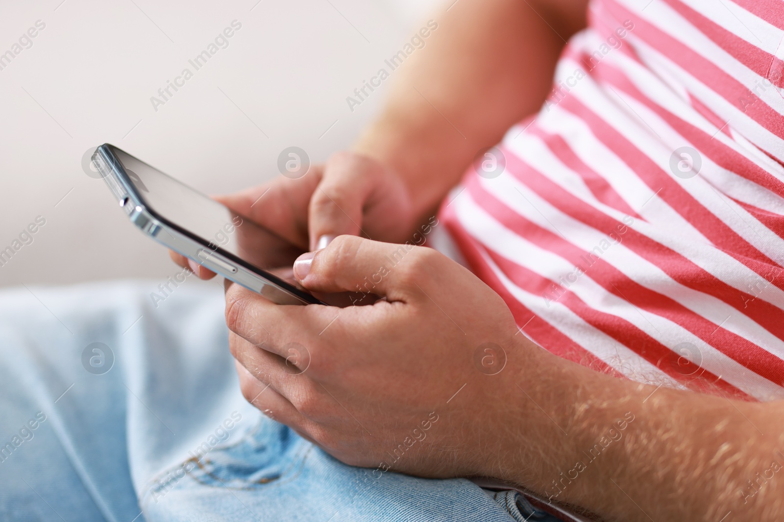 Photo of Man using smartphone on blurred background, closeup