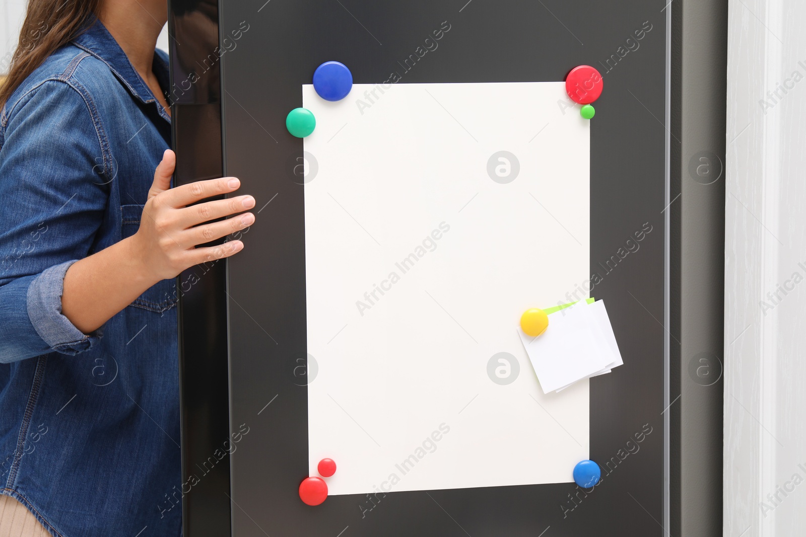 Photo of Woman opening refrigerator with blank magnetic board and note in kitchen, closeup