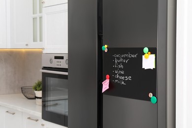 Magnetic board with shopping list and notes on refrigerator in kitchen