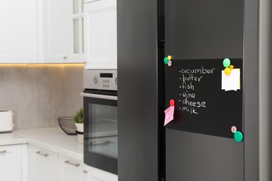 Photo of Magnetic board with shopping list and notes on refrigerator in kitchen