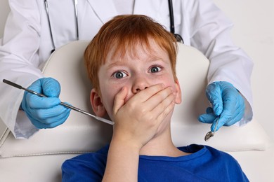 Dental phobia. Dentist working with scared little boy