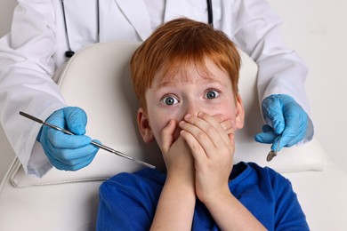 Dental phobia. Dentist working with scared little boy