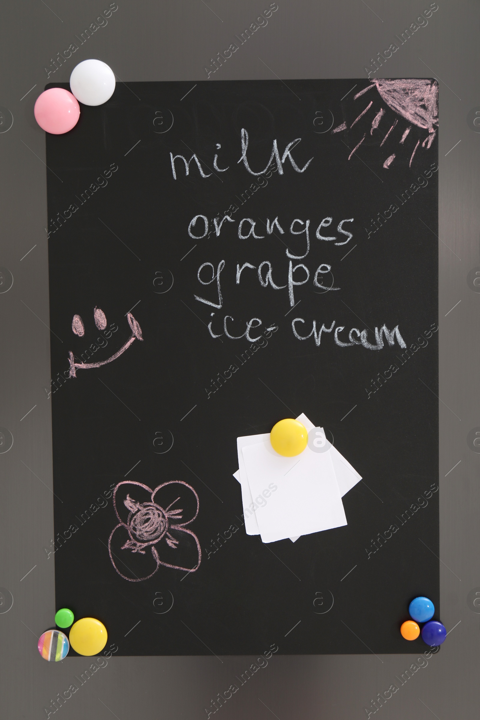 Photo of Magnetic board with shopping list and notes on refrigerator in kitchen