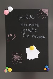 Magnetic board with shopping list and notes on refrigerator in kitchen