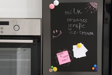 Photo of Magnetic board with shopping list and notes on refrigerator in kitchen