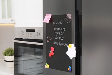 Magnetic board with shopping list and notes on refrigerator in kitchen