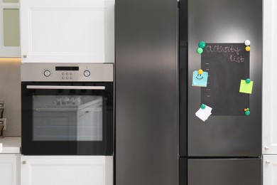 Magnetic board with activity list and notes on refrigerator in kitchen