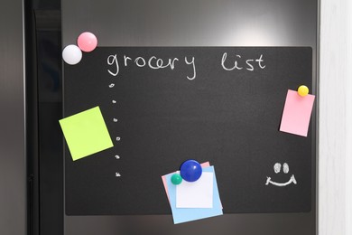 Magnetic board with grocery list and notes on refrigerator in kitchen