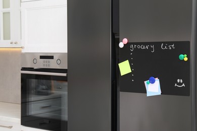 Photo of Magnetic board with grocery list and notes on refrigerator in kitchen