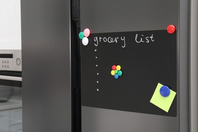 Magnetic board with grocery list and note on refrigerator in kitchen