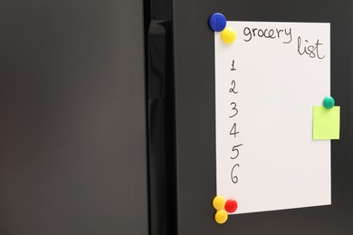 Magnetic board with grocery list and note on refrigerator in kitchen