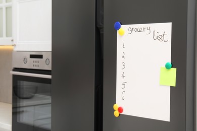 Photo of Magnetic board with grocery list and note on refrigerator in kitchen