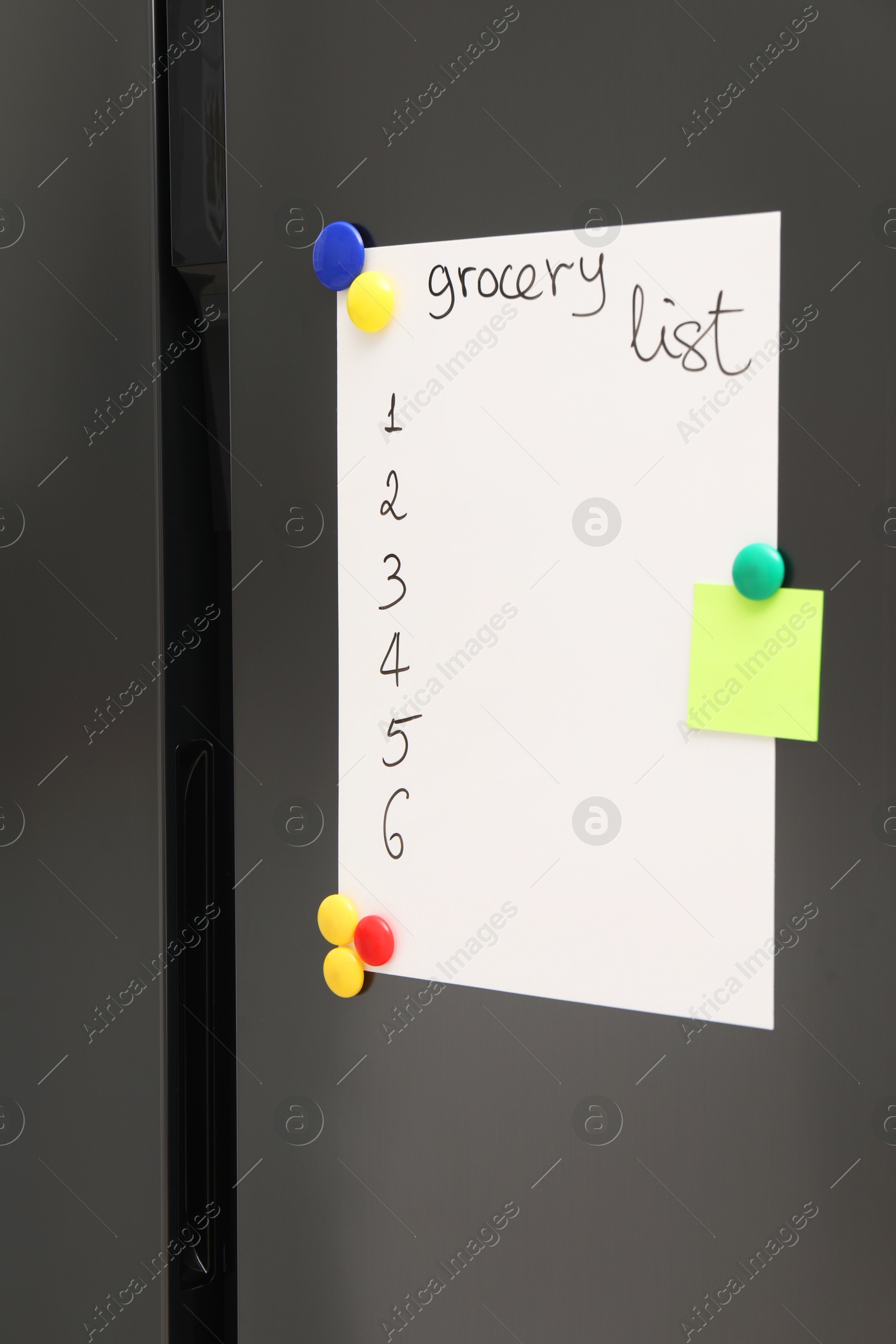 Photo of Magnetic board with grocery list and note on refrigerator in kitchen