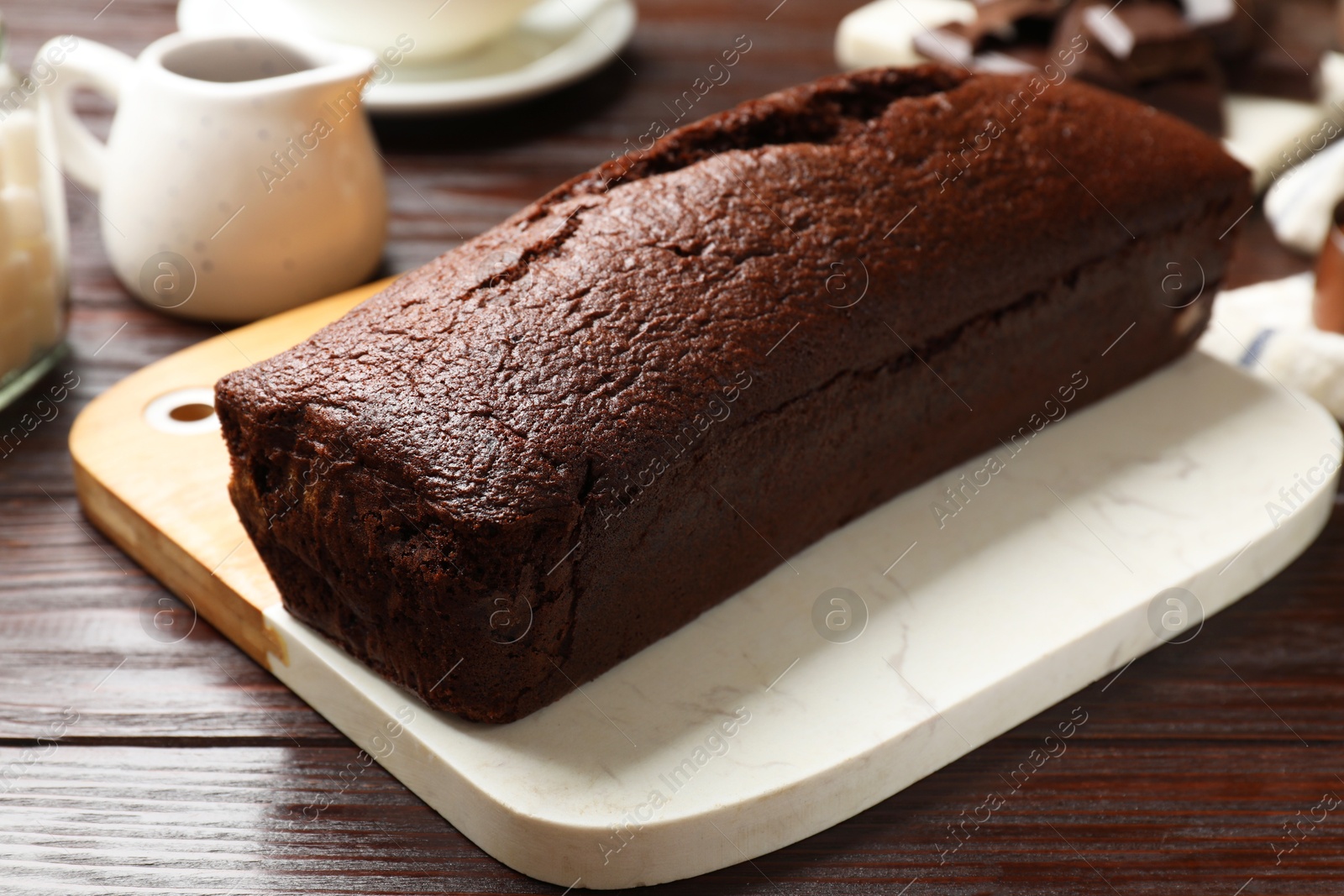 Photo of Tasty chocolate sponge cake on wooden table, closeup