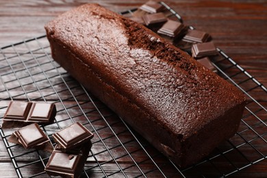 Photo of Tasty chocolate sponge cake and ingredients on wooden table, closeup