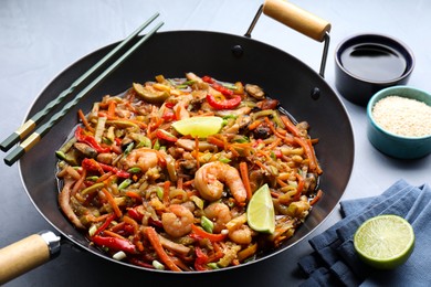 Stir-fry sea food in wok served on grey table