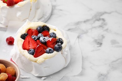 Photo of Pavlova cake (meringue dessert) with whipped cream, fresh berries and powdered sugar on white marble table, closeup. Space for text