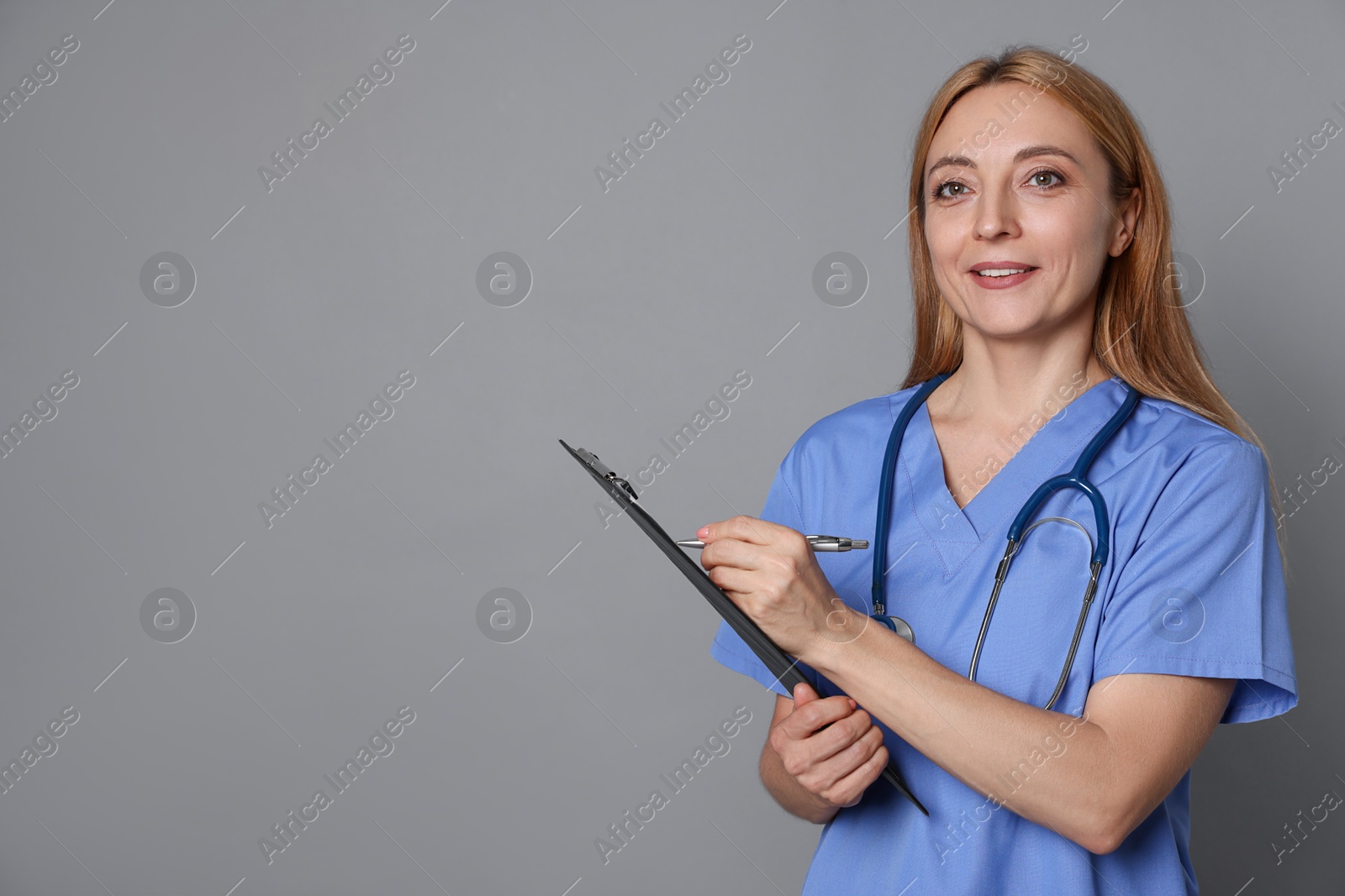 Photo of Doctor with clipboard writing notes on gray background, space for text