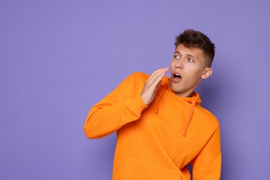 Portrait of scared young man on violet background, space for text