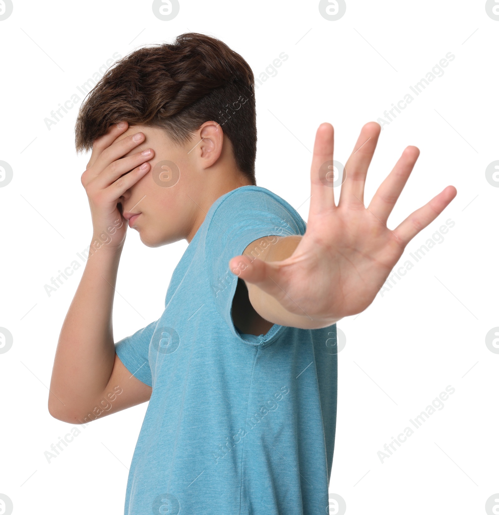 Photo of Scared teenage boy covering face with hand on white background