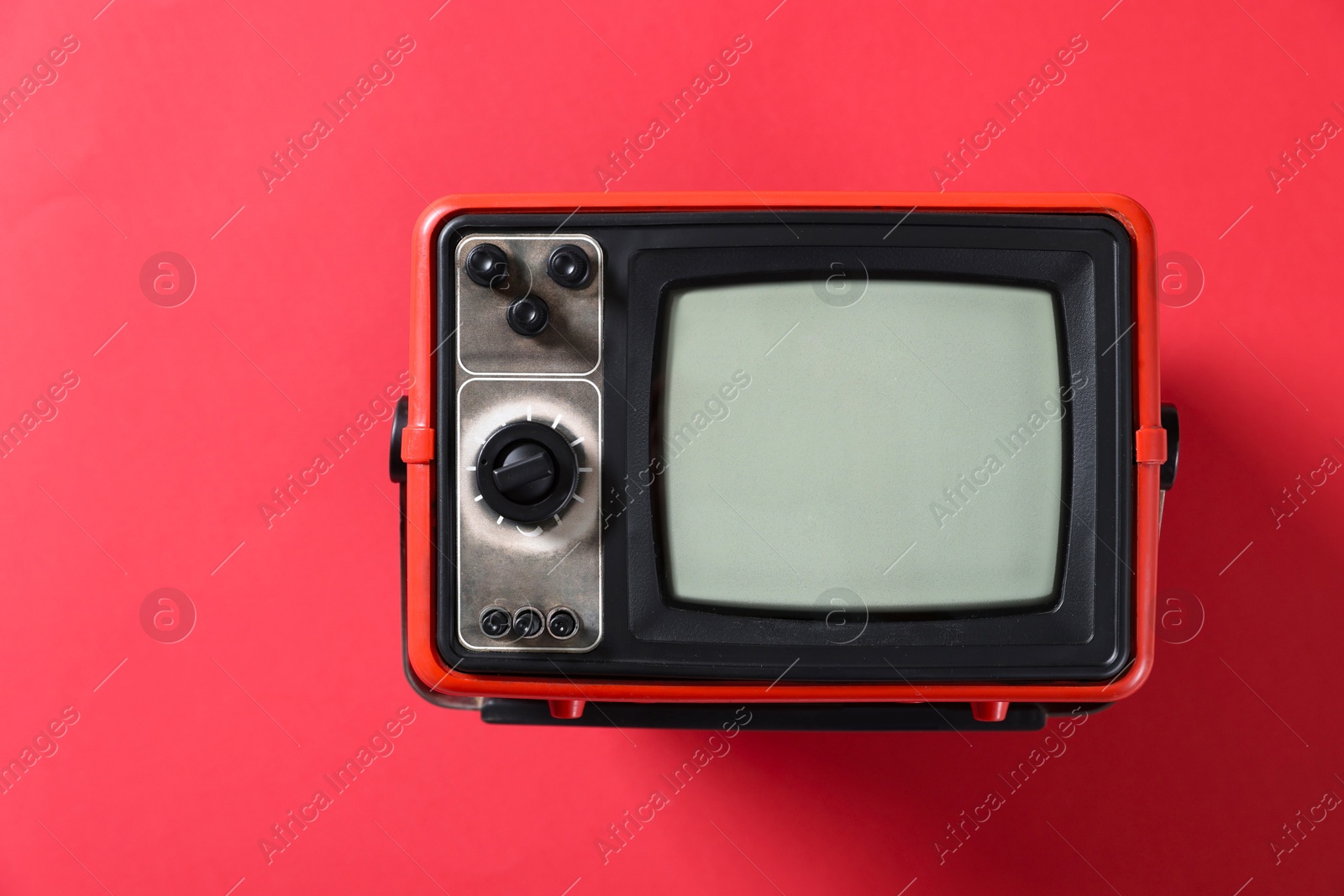 Photo of Retro tv set on red background, top view