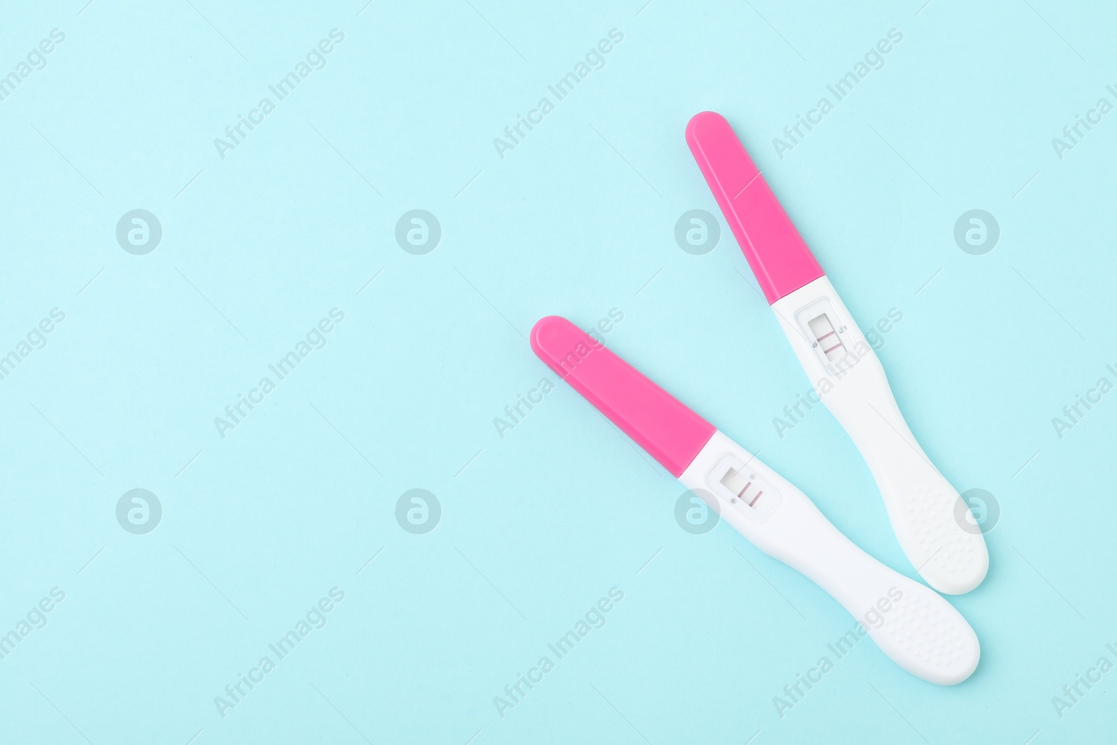 Photo of Pregnancy tests on light blue background, top view