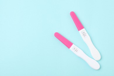 Photo of Pregnancy tests on light blue background, top view