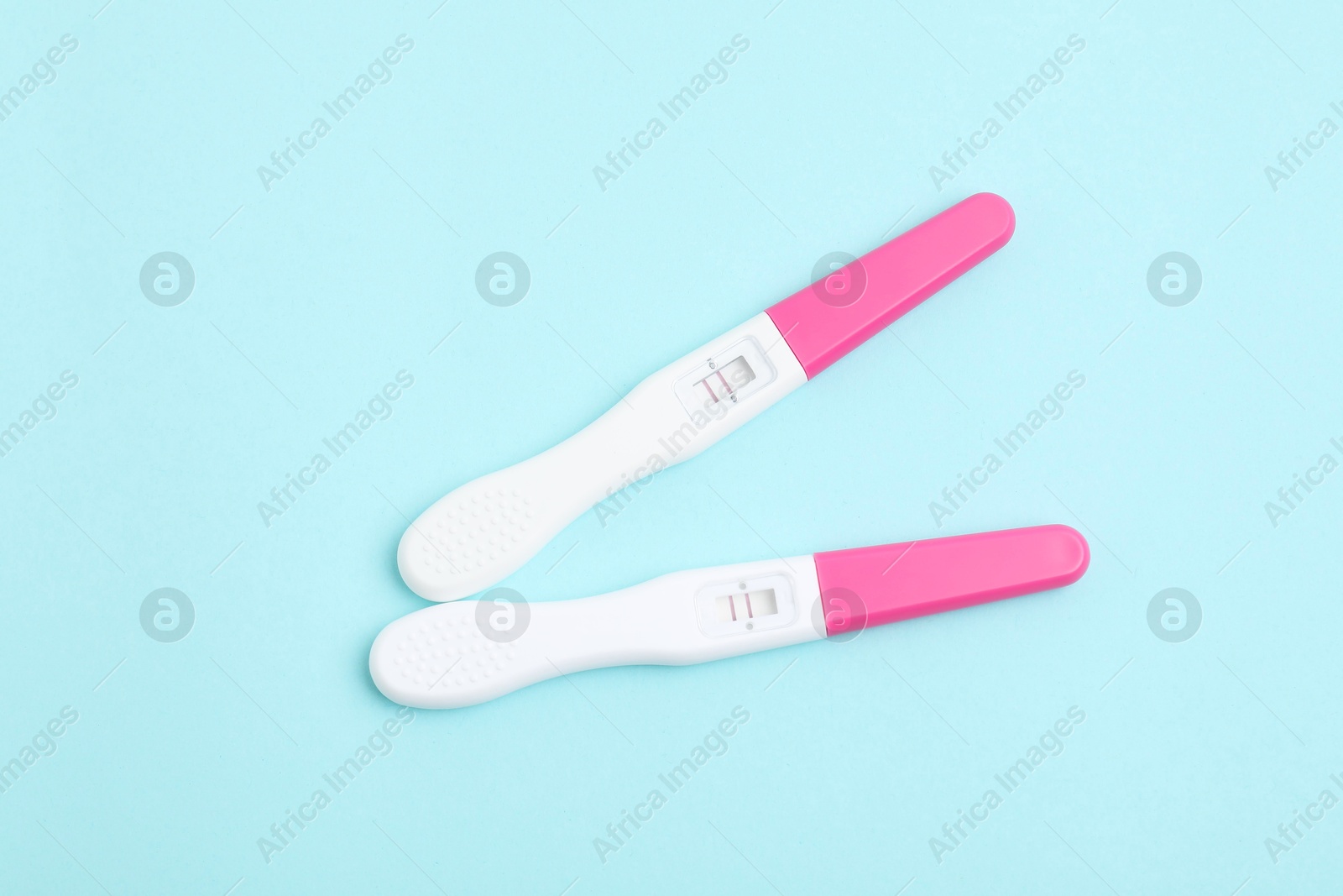 Photo of Pregnancy tests on light blue background, top view