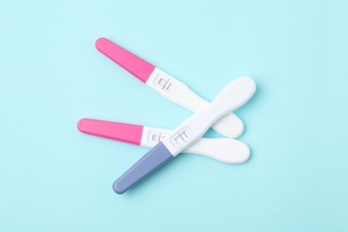 Photo of Pregnancy tests on light blue background, top view