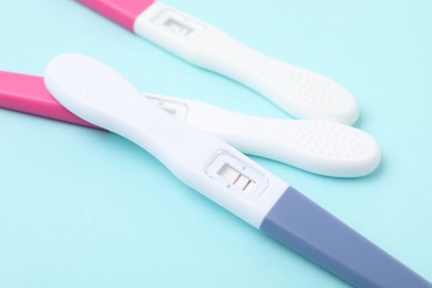 Photo of Pregnancy tests on light blue background, closeup