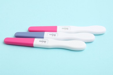 Photo of Pregnancy tests on light blue background, closeup