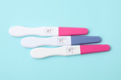 Photo of Pregnancy tests on light blue background, above view