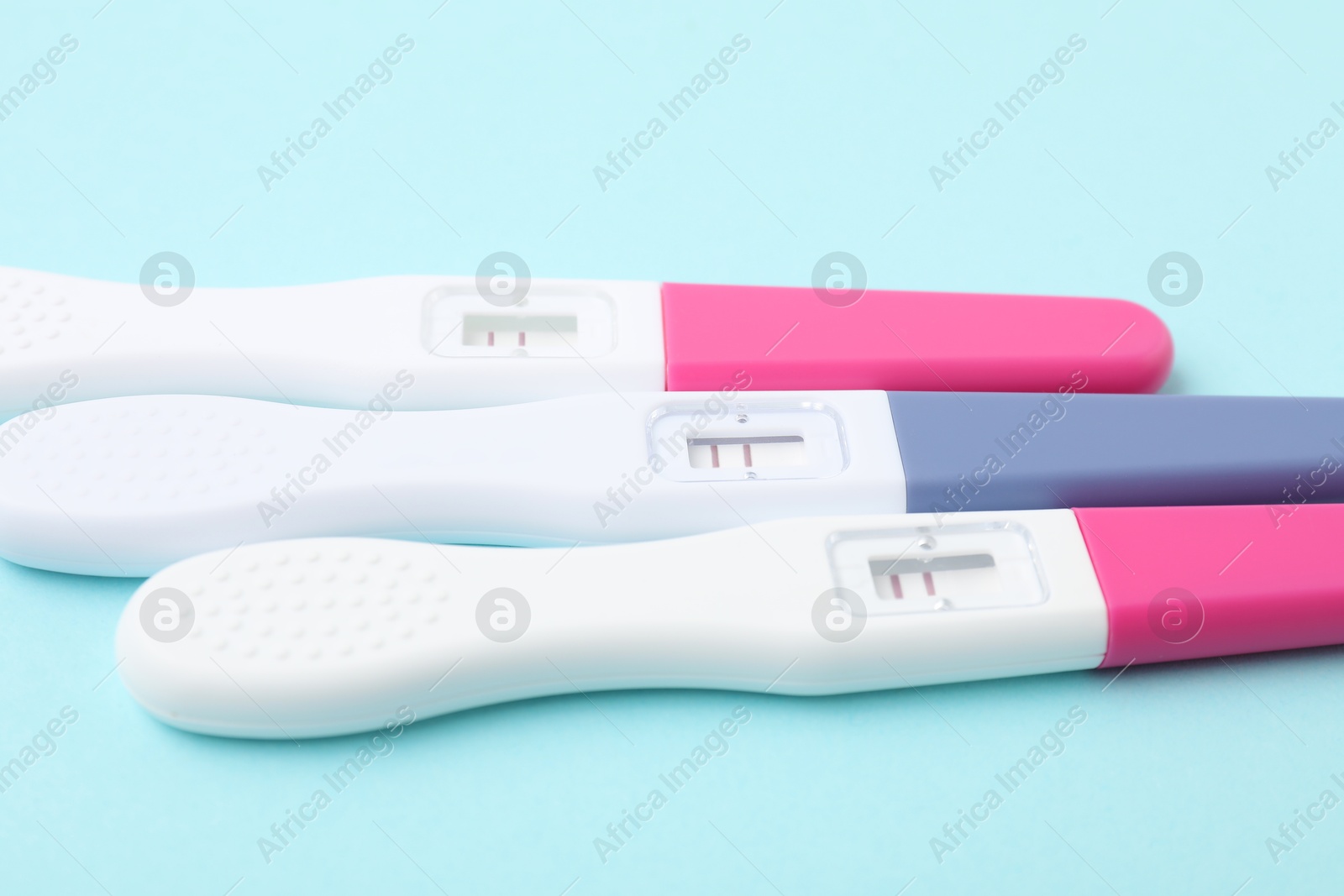 Photo of Pregnancy tests on light blue background, closeup