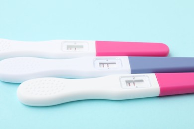 Photo of Pregnancy tests on light blue background, closeup