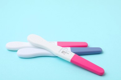 Photo of Pregnancy tests on light blue background, closeup