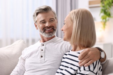 Photo of Happy middle aged couple on sofa at home