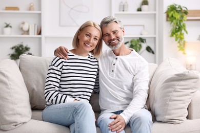 Photo of Happy middle aged couple on sofa at home