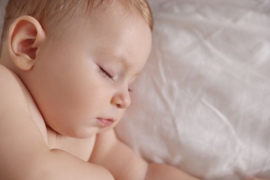 Photo of Cute little baby sleeping on bed, top view