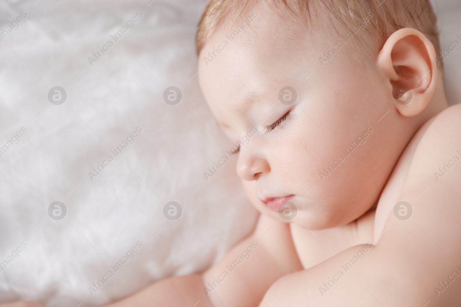 Photo of Cute little baby sleeping on bed, top view