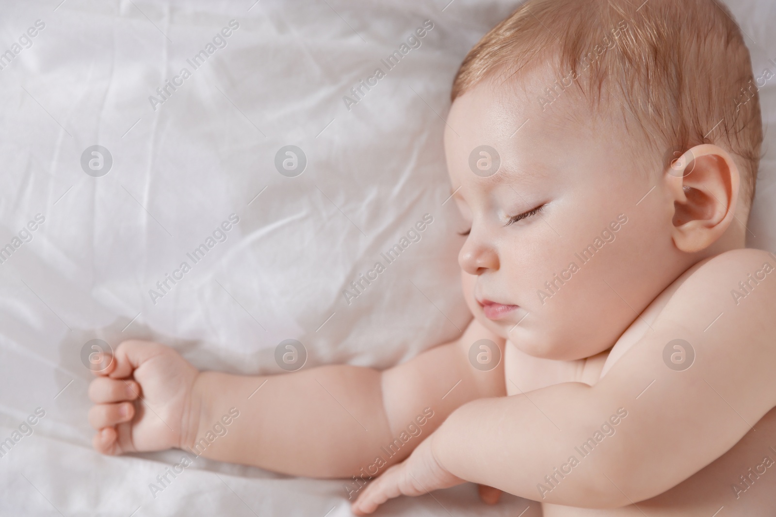 Photo of Cute little baby sleeping on bed at home, top view